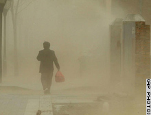 A man walks through a dust cloud in Beijing on Monday after sand storms blanketed other parts of northern China.